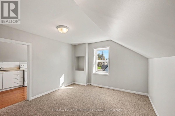 View of a carpeted room with light gray walls and a small window overlooking the street. - Unit 1 - 216 Bell Street, Arnprior