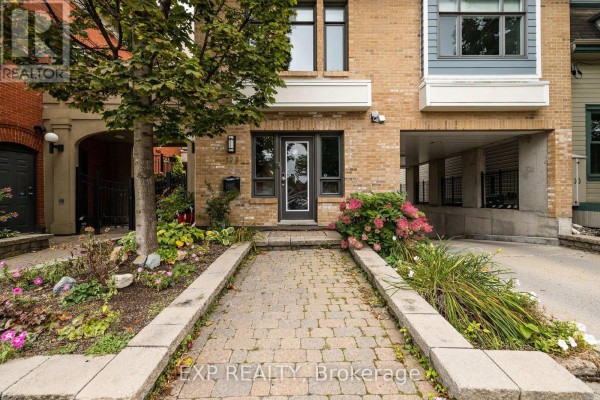 Stone pathway leading to a glass-paneled front door of a brick building. - Unit 1 Level 1 - 122 Guigues Avenue W, Ottawa
