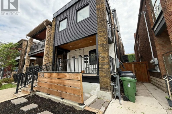 Exterior view of the lower unit entrance with a modern facade and brick accents. - Unit 1 Lower - 2134 Dundas Street W, Toronto