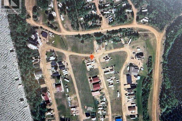 Moose walking in Elinor Lake with trees and cabins on the shore. - Unit 118, 65275 Range Road 114a, Lac La Biche