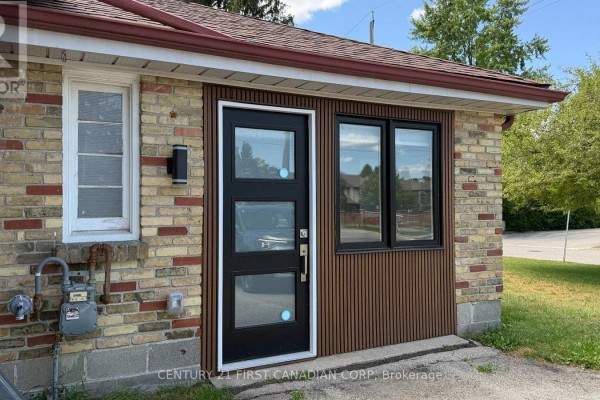 Close-up of the modern black front door with frosted glass panels and vertical siding next to it. - Unit 2 - 1473 Adelaide Street N, London North