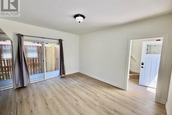 Bathroom with a white vanity, silver faucet, toilet, and a glass shower stall. - Unit 2 - 4711 River Road, Niagara Falls
