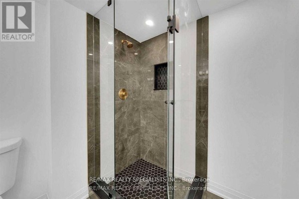 Glass-enclosed shower with marble tile and hexagon floor tiles. - Unit 2 - 7294 Rosehurst Drive, Mississauga