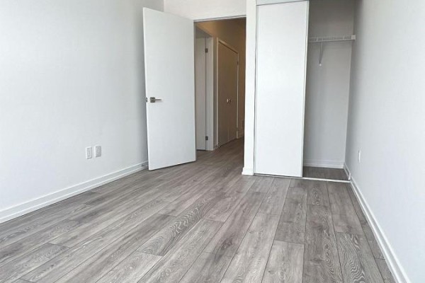 Empty room with light wood-look flooring and white doors. - Unit 20-24 Lytham Green Circle, Newmarket
