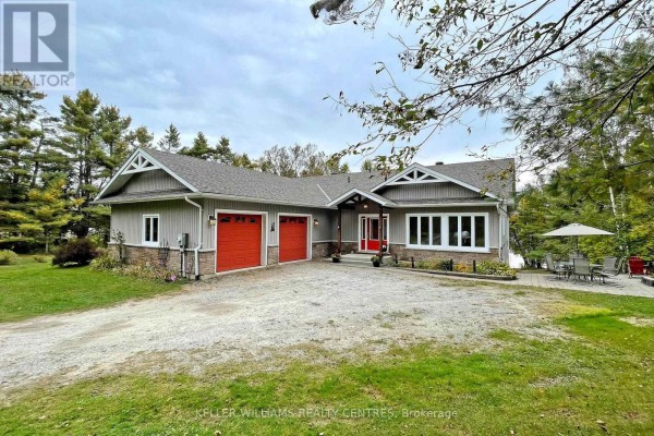 Front view of a single-story grey house with a pitched roof, stone accents, and three garage doors. - Unit 4 - 1623 Houseys Rapids Road, Gravenhurst