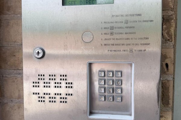 Close-up of a stainless steel intercom system with a keypad and digital display. - Unit 5 - 108 Queen Street N, West Grey