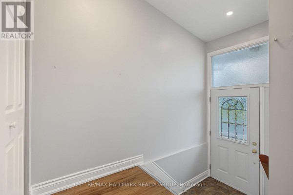 Interior view of a light grey entryway with a white door with frosted glass. - Unit A (upper Unit) - 1135 Maitland Avenue, Ottawa