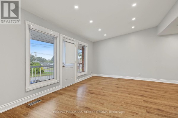Living room with light wood laminate flooring, white walls, and a glass door. - Unit A (upper Unit) - 1135 Maitland Avenue, Ottawa