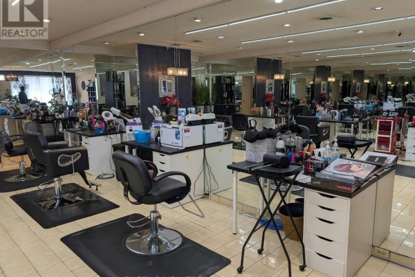 Salon interior with multiple styling chairs, cabinets, and mirrored walls reflecting the space. - Unit C - 3477 Portage Road, Niagara Falls