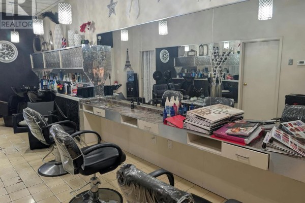 Hair salon seating area with chairs, mirrors, product shelves, and decorative elements. - Unit C - 3477 Portage Road, Niagara Falls