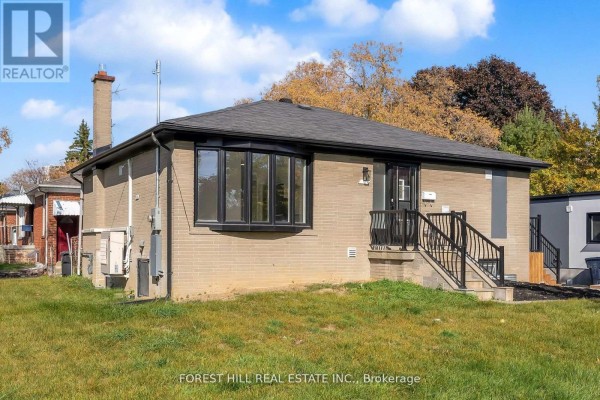 Exterior view of a beige brick bungalow with a dark roof and a bay window. - Unit D - 105 Galloway Road, Toronto