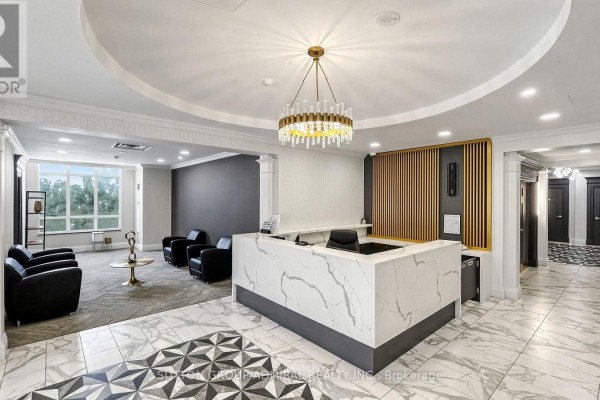 A modern reception desk with a white marble counter and a contemporary brass chandelier. - Uph09 - 28 Byng Avenue, Toronto