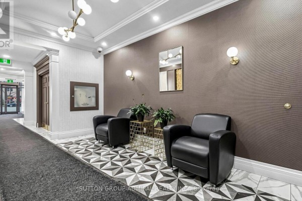 A hotel-style hallway with two black leather armchairs, a geometric tiled floor, and textured brown walls. - Uph09 - 28 Byng Avenue, Toronto