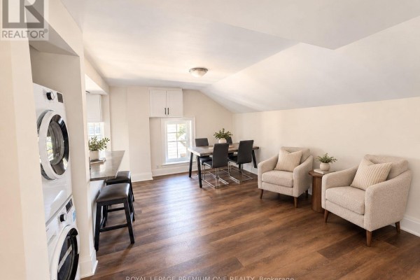 Laundry machines next to a small counter and dining area with two chairs. - Upper - 10496 Islington Avenue, Vaughan