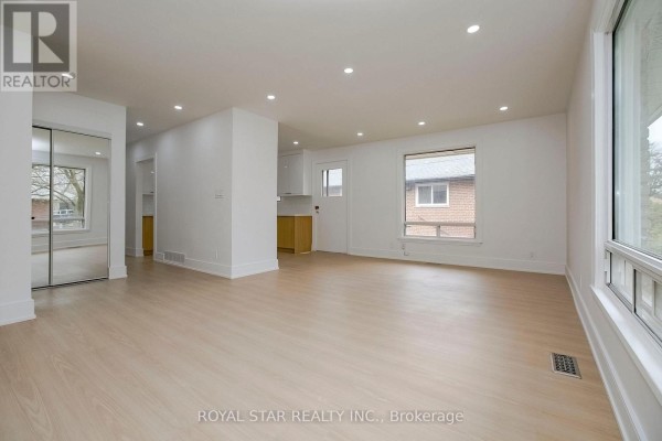 Bright unfinished basement room with light wood flooring and white walls. - Upper - 114 Wincott Drive, Toronto