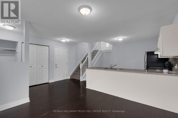 Kitchen island with double sink and granite countertop, white cabinets, and dark curtains. - Upper - 152 Madelaine Drive, Barrie