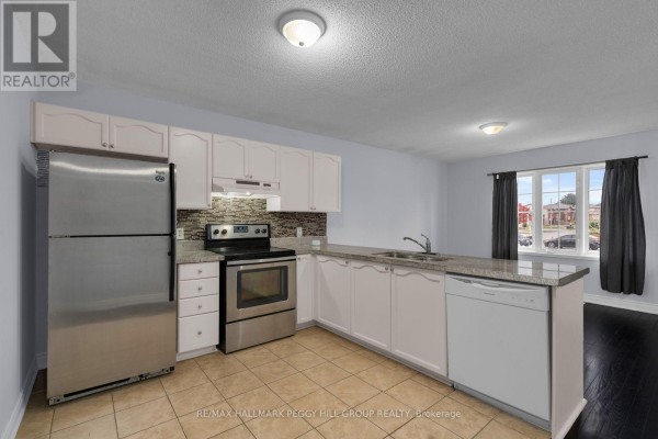 View from kitchen towards staircase and hallway with dark wood floors. - Upper - 152 Madelaine Drive, Barrie