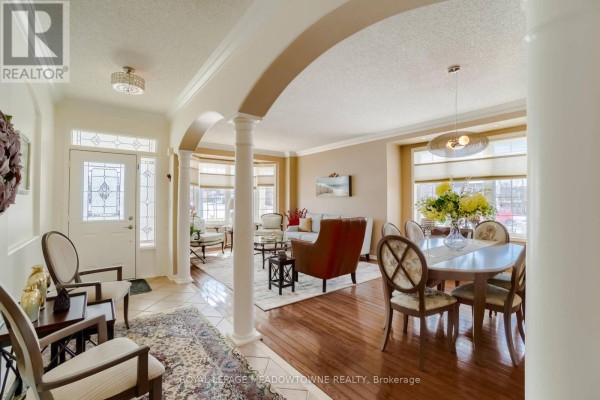 Interior view of a foyer and living room with hardwood floors, a dining table, and furniture. - Upper - 1583 Beaty Trail, Milton