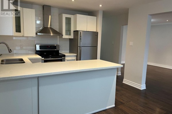 Kitchen with white countertops, island, stainless steel appliances, and doorway to living room. - Upper - 211 Silverbirch Drive, Newmarket