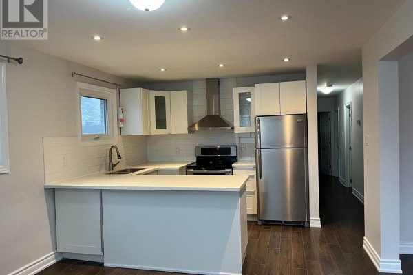 Kitchen and hallway with dark wood floors, white cabinets, and stainless steel appliances. - Upper - 211 Silverbirch Drive, Newmarket