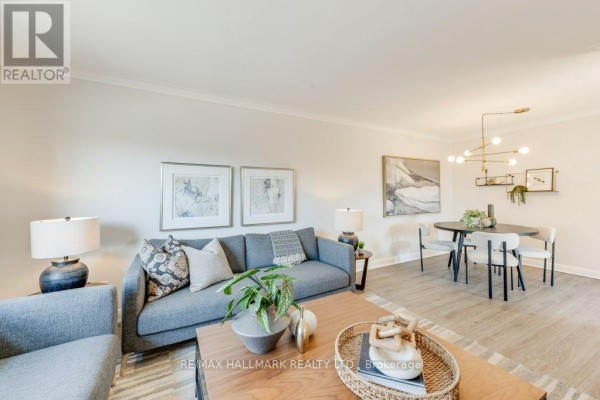 Living room and dining area with sectional sofa, dining table, chairs, and modern light fixture. - Upper - 225 Woodville Avenue, Toronto