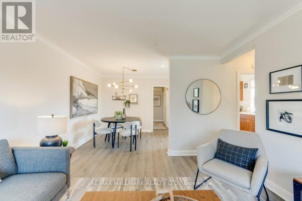 Open concept living and dining area with furniture, hallway entrance, and artwork on the wall. - Upper - 225 Woodville Avenue, Toronto
