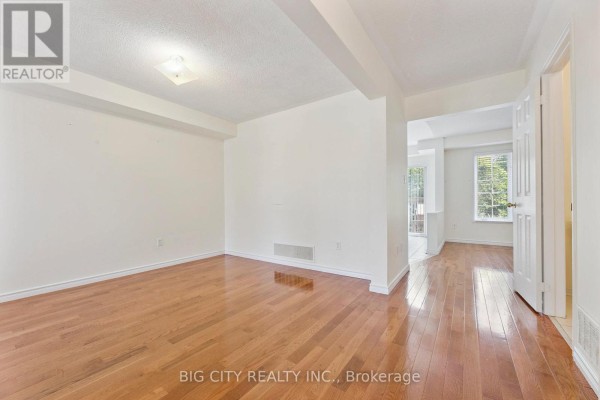 Empty living room with light walls and polished hardwood floors, view of hallway. - Upper - 23 Angier Crescent, Ajax