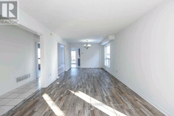 Spacious living room with wood-like flooring, large windows, and a chandelier - Upper - 24 Hayloft Court, Brampton