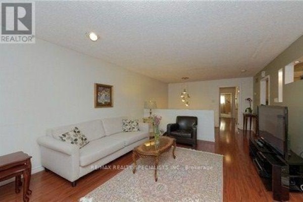 Living room with white sofa, leather armchair, and wooden coffee table on rug. - Upper - 290 Mcnicoll Avenue, Toronto