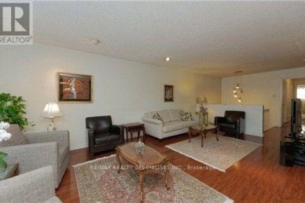 Living area with white sofa, two leather armchairs, and wooden flooring. - Upper - 290 Mcnicoll Avenue, Toronto