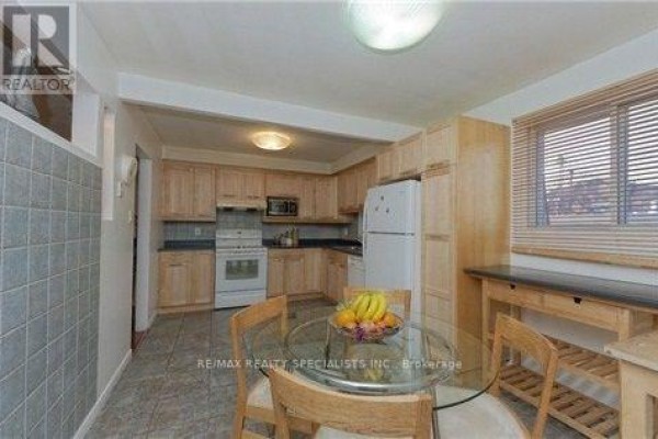 Kitchen with light wood cabinets, white appliances, and a glass dining table. - Upper - 290 Mcnicoll Avenue, Toronto