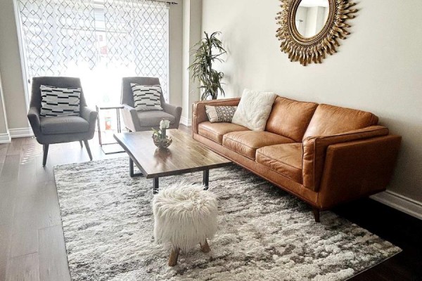 Living room with a brown leather sofa, two grey chairs, and a wooden coffee table. - Upper - 2951 Kingsway Drive, Oakville