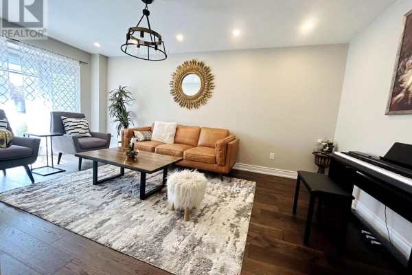 Living room with a brown leather sofa, two grey chairs, a coffee table, and a piano. - Upper - 2951 Kingsway Drive, Oakville