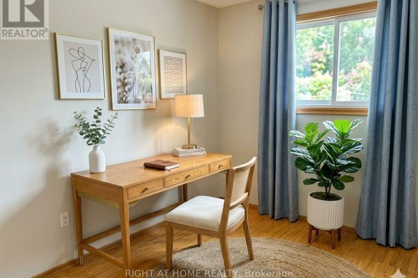 Home office with a wooden desk, chair, lamp, artwork, and blue curtains. - Upper - 30 San Remo Drive, Hamilton