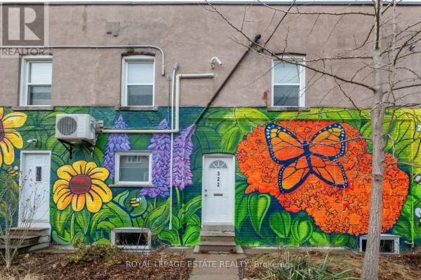Rear exterior of commercial building showing fire escape, beige siding, and a colorful floral mural. - Upper - 322 Silver Birch Avenue, Toronto