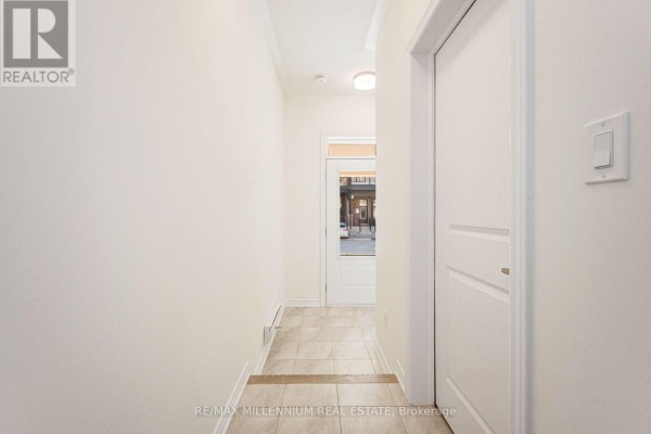 Hallway inside a home with beige tile flooring and a white door leading outside. - Upper - 34 Thornbird Crescent, Brampton
