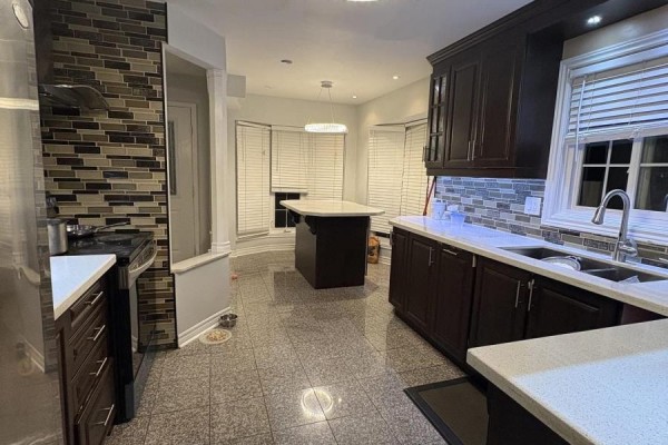 Spacious kitchen with dark wood cabinets, granite countertops, and a breakfast nook with bay windows. - Upper - 36 Beaumont Drive, Ajax