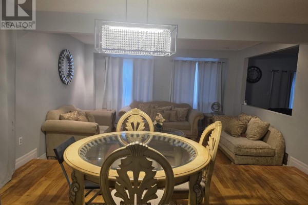 Dining area with a round table, upholstered chairs, and sofas in the background. - Upper - 36 Beaumont Drive, Ajax