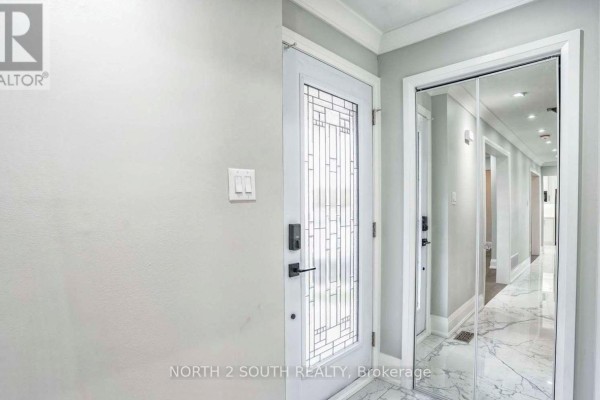 Interior entryway with a glass-paned door and mirrored closet doors. - Upper - 37 Loire Court, Toronto