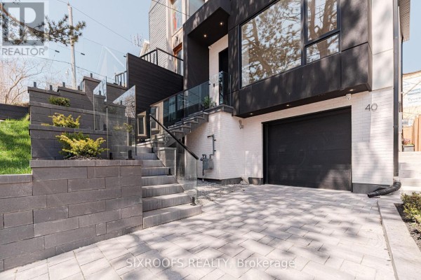 Close-up of modern house entrance with stone steps, glass railings, and garage door. - Upper - 40 Morningside Avenue, Toronto
