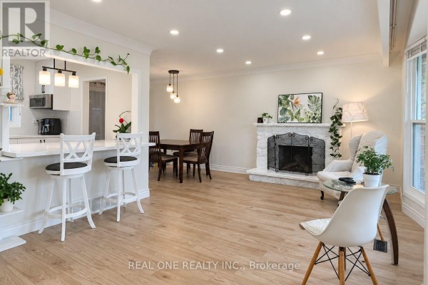 Kitchen with white island and pendant lights, adjacent to dining area and living room. - Upper - 41 Marlowe Drive, Hamilton