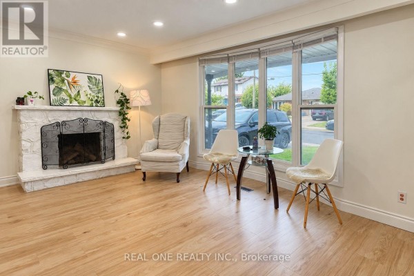 Living room with bay window, armchair, and fireplace with stone surround. - Upper - 41 Marlowe Drive, Hamilton