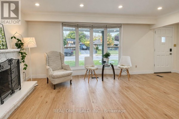 Living room with bay window overlooking street, white armchair, and fireplace. - Upper - 41 Marlowe Drive, Hamilton
