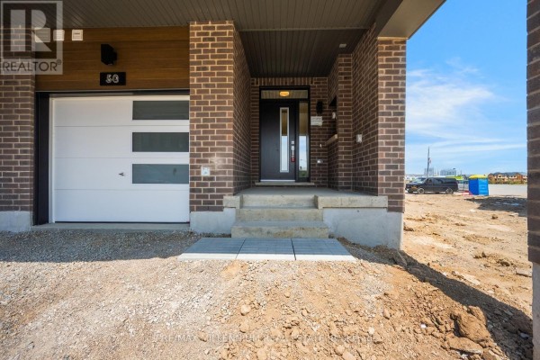 Front entrance of townhouse with dark brick, glass door, and single garage door. - Upper - 50 Thornbird Crescent, Brampton