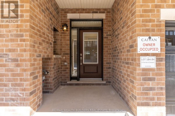 Covered front entrance with a dark brown door, glass sidelights, and brick facade. - Upper - 6 Thornbird Crescent, Brampton