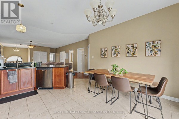 Dining area with a live-edge wood table and a view into the living room. - Upper - 65 Jessica Drive, Barrie