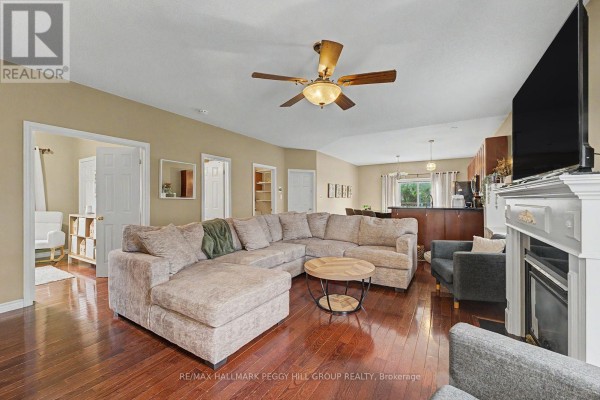 Living room with a large sectional sofa, coffee table, and fireplace. - Upper - 65 Jessica Drive, Barrie
