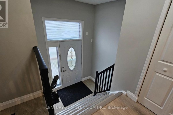 Front entranceway with a white door, oval glass insert, and wide window above. - Upper - 67 Simmons Boulevard, Brampton
