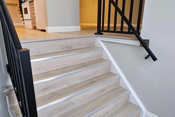 Light wood laminate stairs with silver metal edging and black metal railings. - Upper - 67 Simmons Boulevard, Brampton