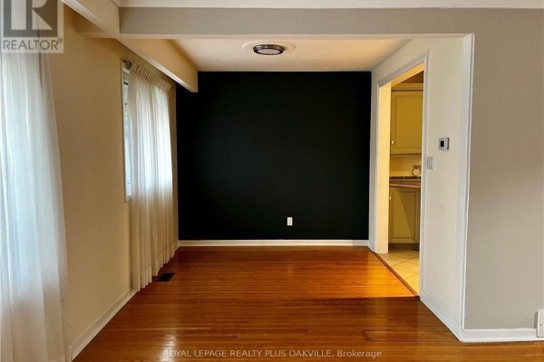 Dining room with hardwood floors and a dark accent wall, adjacent to the kitchen. - Upper - 694 Niagara Street, St  Catharines